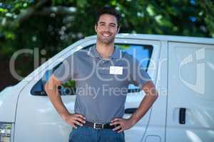 Portrait of happy delivery person with hand on hip