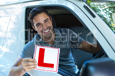 Portrait of happy man with leaning sign