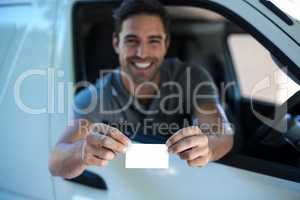 Smiling driver man showing blank card