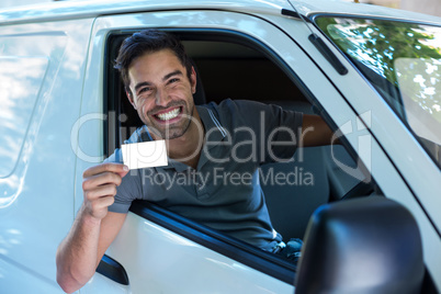 Handsome driver with toothy smiling showing blank card