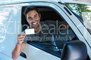 Handsome driver with toothy smiling showing blank card