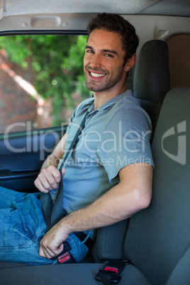 Handsome driver fastening car seat belt