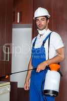 Confident pest worker holding sprayer