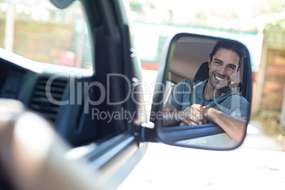Handsome man sitting in car on mirror