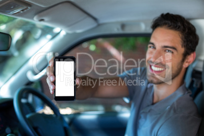 Handsome man holding phone in car