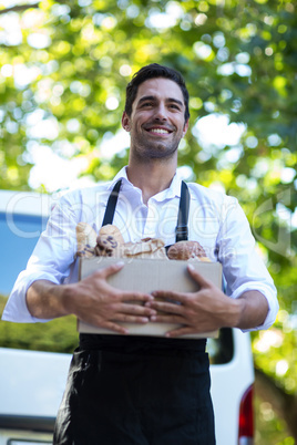 Happy delivery person carrying food package