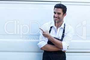 Portrait of confident delivery man pointing