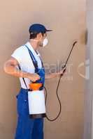 Man spraying pesticide on wall