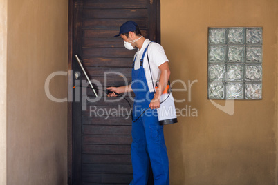 Worker spraying chemical on door