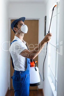 Side view of worker using pesticide