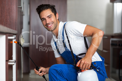Portrait of confident pesticide worker crouching
