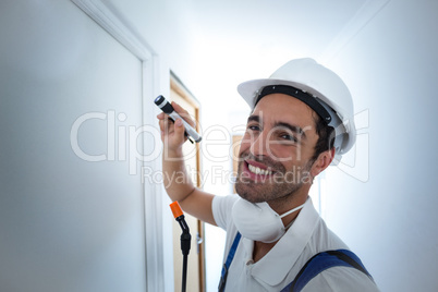 Portrait of happy worker using flashlight