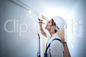 Side view of worker using flashlight in hallway