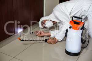 Worker using flashlight under cabinet