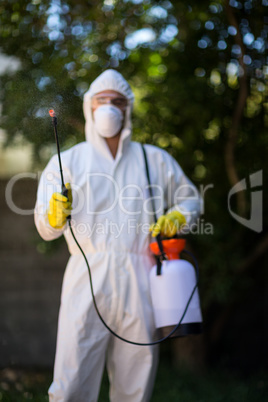 Front view of worker spraying chemical