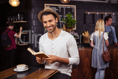 A man is reading a book and smiling