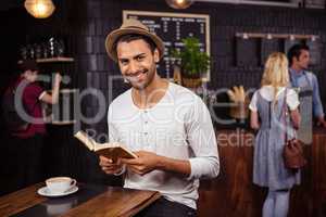 A man is reading a book and smiling