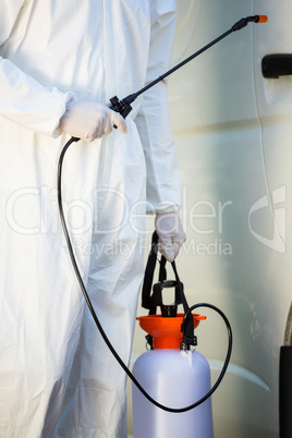 Mid section of pest control man standing next to a van