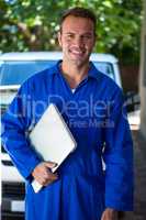 Portrait of mechanic holding a laptop