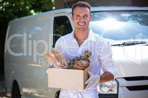 Delivery man standing in front of his van