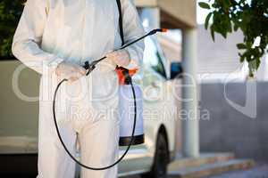 Mid section of pest control man standing next to a van