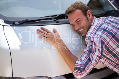 Young man hugging his car