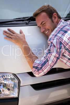 Young man hugging his car