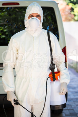 Pest control man standing behind a van