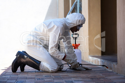 Side view of a man doing pest control