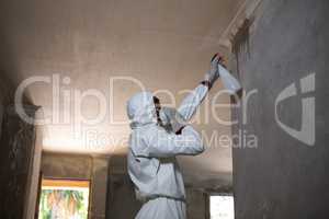 Man doing pest control on a wall