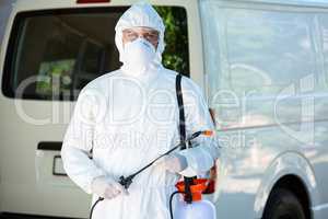 Pest control man standing behind a van