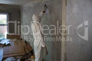 Man doing pest control on a wall