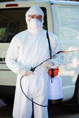 Pest control man standing behind a van