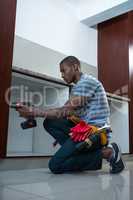 Manual worker drilling a hole in kitchen