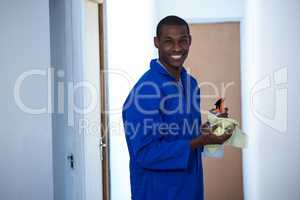 Happy handyman holding spraying insecticide and napkin