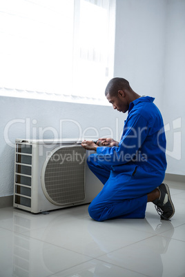 Handyman testing air conditioner