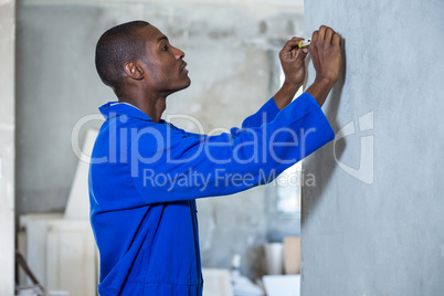 Handyman measuring a wall