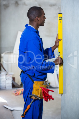 Handyman measuring a wall with spirit level