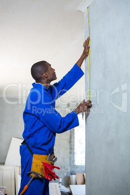 Handyman measuring a wall