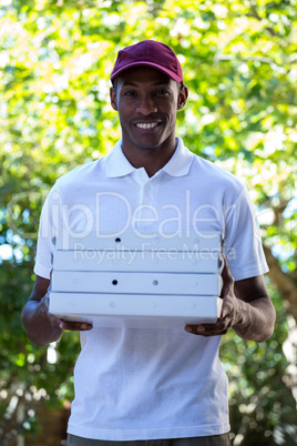 Happy delivery man holding pizza boxes