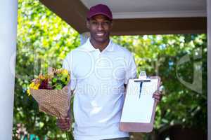 Delivery man holding flower bouquet and clipboard