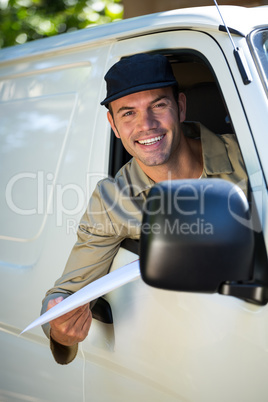 Smiling delivery man sitting in his van