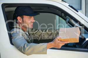 Smiling delivery man sitting in his van