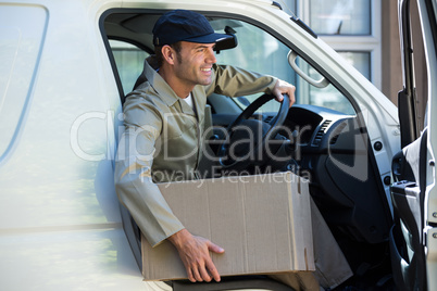 Smiling delivery man getting out from