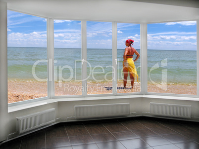 window with view to the sea and sunburnting girl