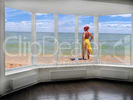 window with view to the sea and sunburnting girl