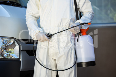 Mid section of pest control man standing next to a van