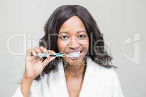 Portrait of a young woman brushing her teeth