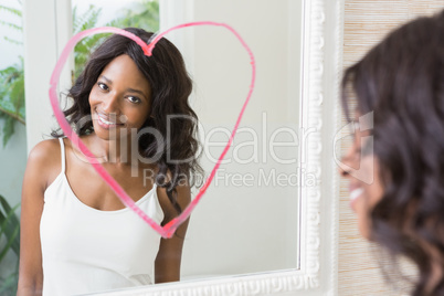 Beautiful young woman looking in the mirror