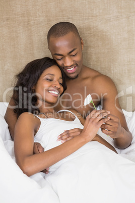 Young man offering a flower to woman